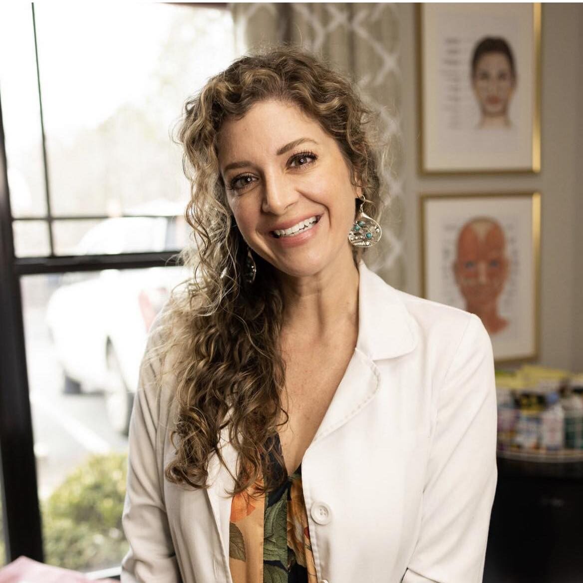 Dr. Lindsay Dowis in a white doctor's coat, smiling at the camera.